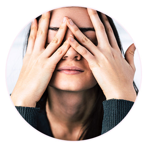 stressed woman with both hands pressed up against her face