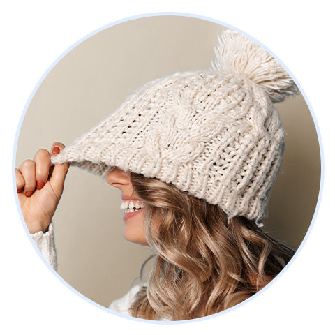 woman wearing a winter hat pulling it down over her forehead