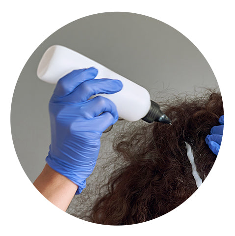 person applying solution to damaged curls