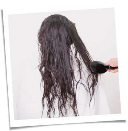 Image of a model brushing through tangled hair.