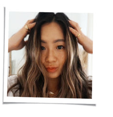 woman with dark wavy hair ruffling her hair