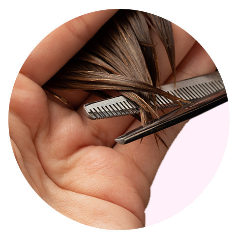 close-up of dark hair getting trimmed