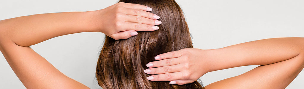 woman with brown hair touching the back of her head