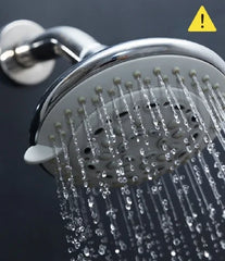 Water coming out of a showerhead with a caution symbol over it.