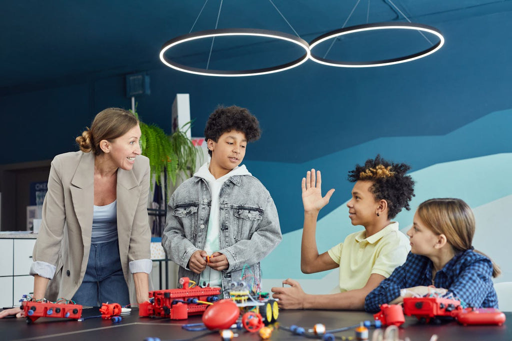 Group of kids having fun with 3d printing toy cars in a classroom