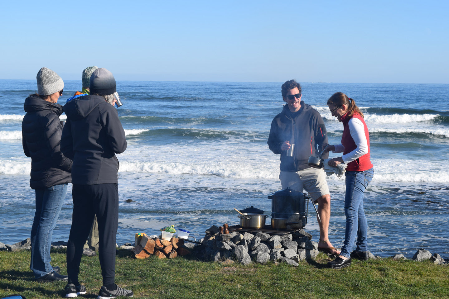 People standing around on a campfire on the Maine coast