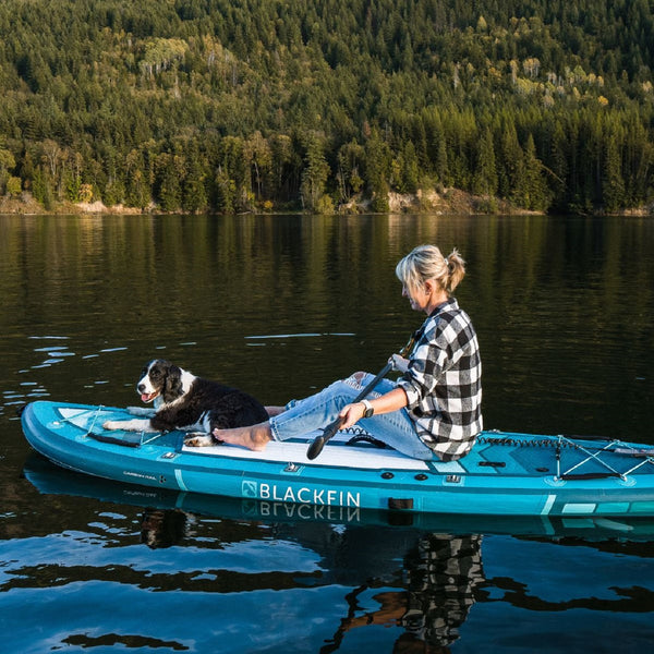 Woman and dog riding BLACKFIN standup paddle board