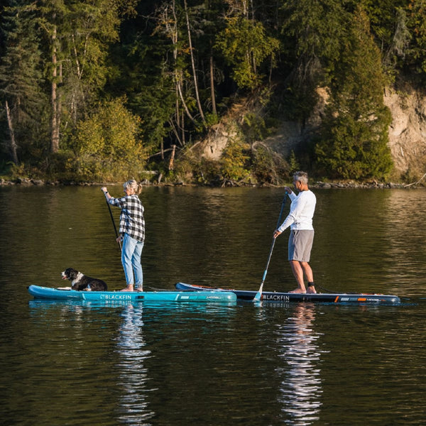 Couple and dog riding their BLACKFIN standup paddle board