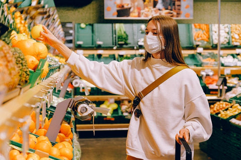 Young woman wearing white mask food shopping