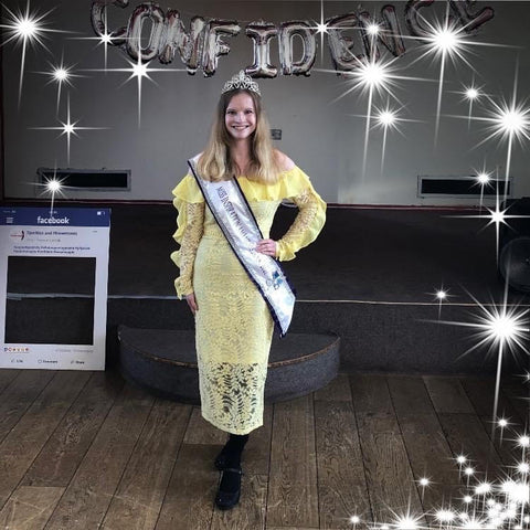 Adrianne pictured in yellow dress wearing pageant sash