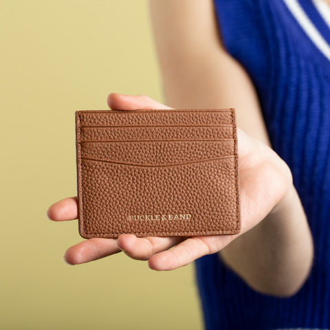 Brown Buckle and Band card wallet being held by a female arm