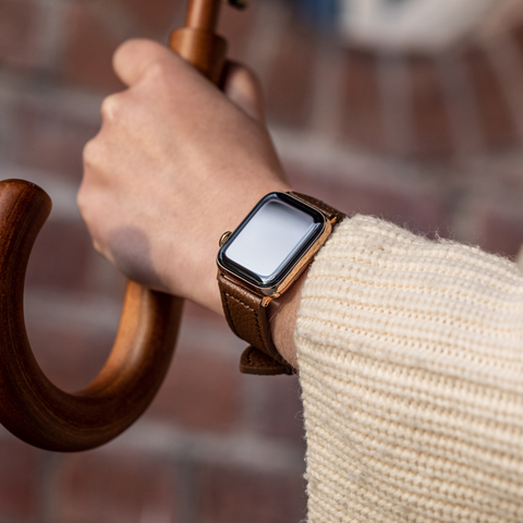 Buckle and Band brown Vegan leather Apple Watch strap, being worn on the wrist of someone holding an umbrella