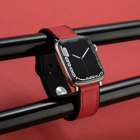 Buckle and Band red Hybri Apple Watch sports strap in front of a red background