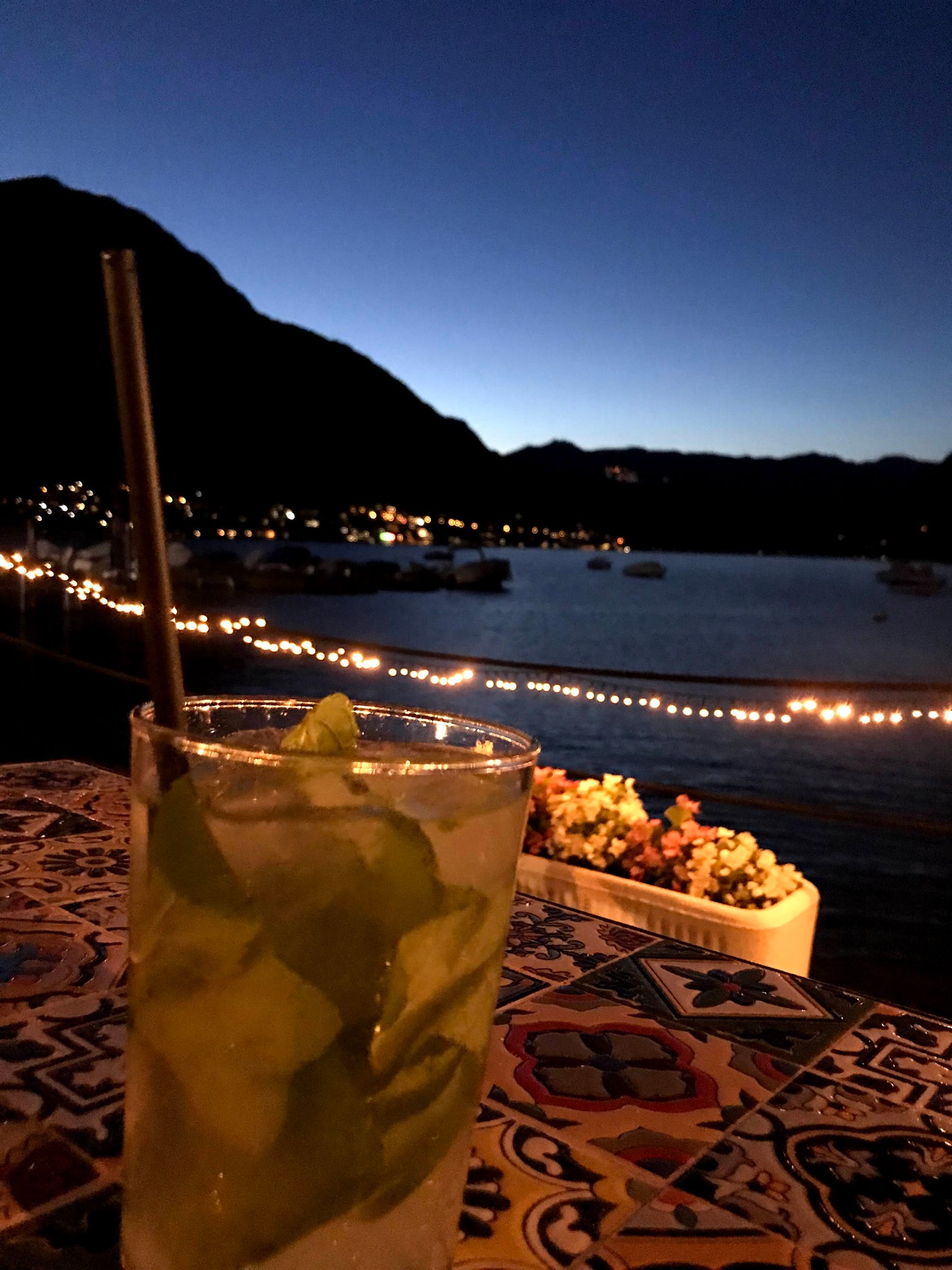 夏の夜を思わせるお酒の入ったグラス越しに海の写真