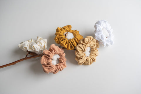 KOOSHOO scrunchies hung atop a branch of organic cotton