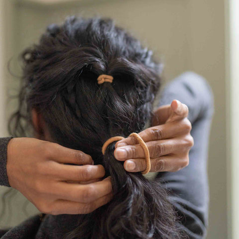 KOOSHOO plant-based hair ties Minis and Mondos being used together in dark hair