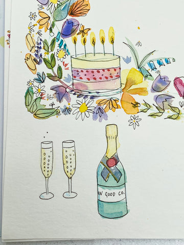 Close up of bottle/glasses/birthday cake elements