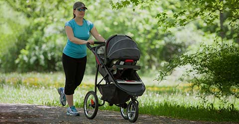 A mother walking her baby on travel system