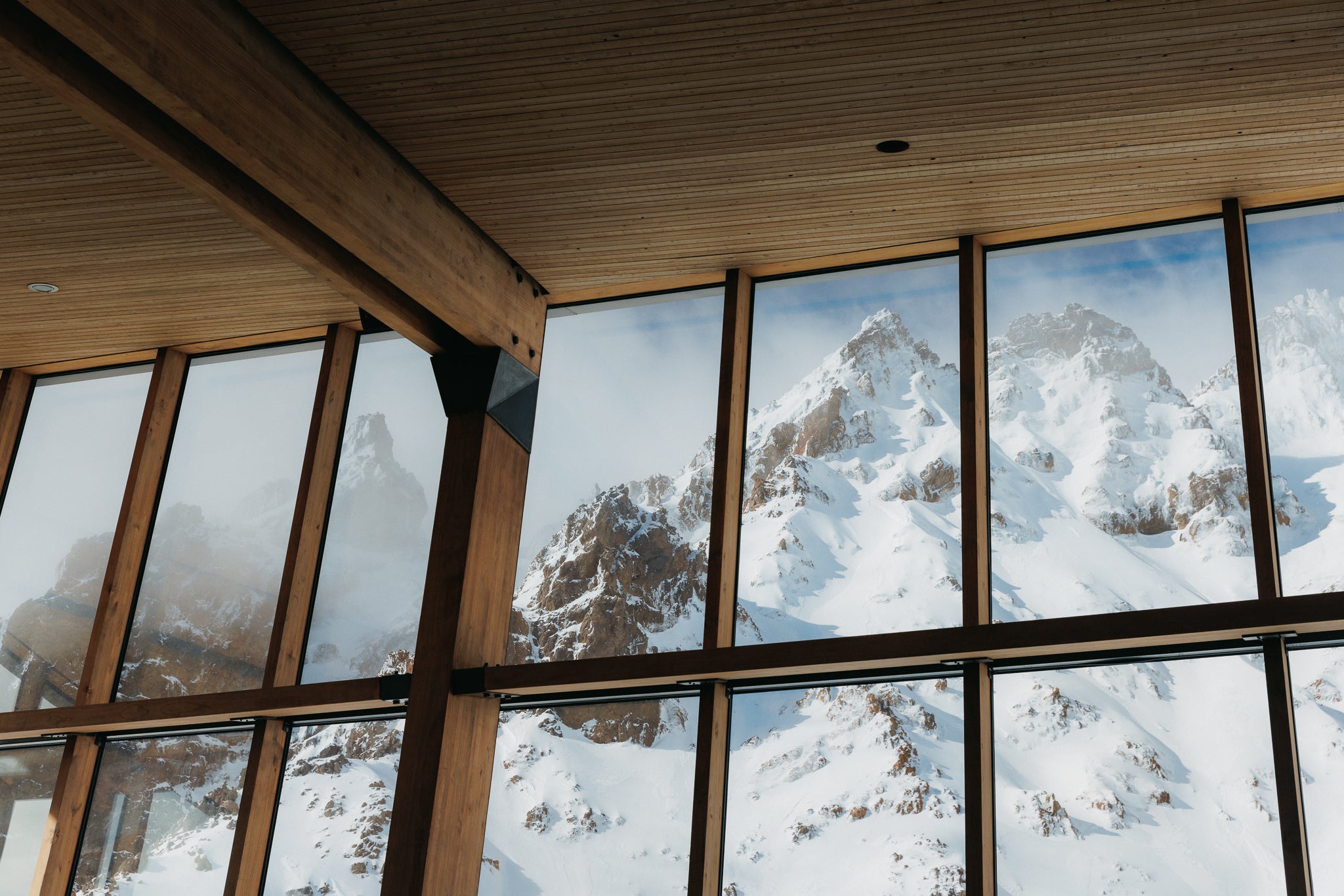 View of snowing mountain from inside chalet