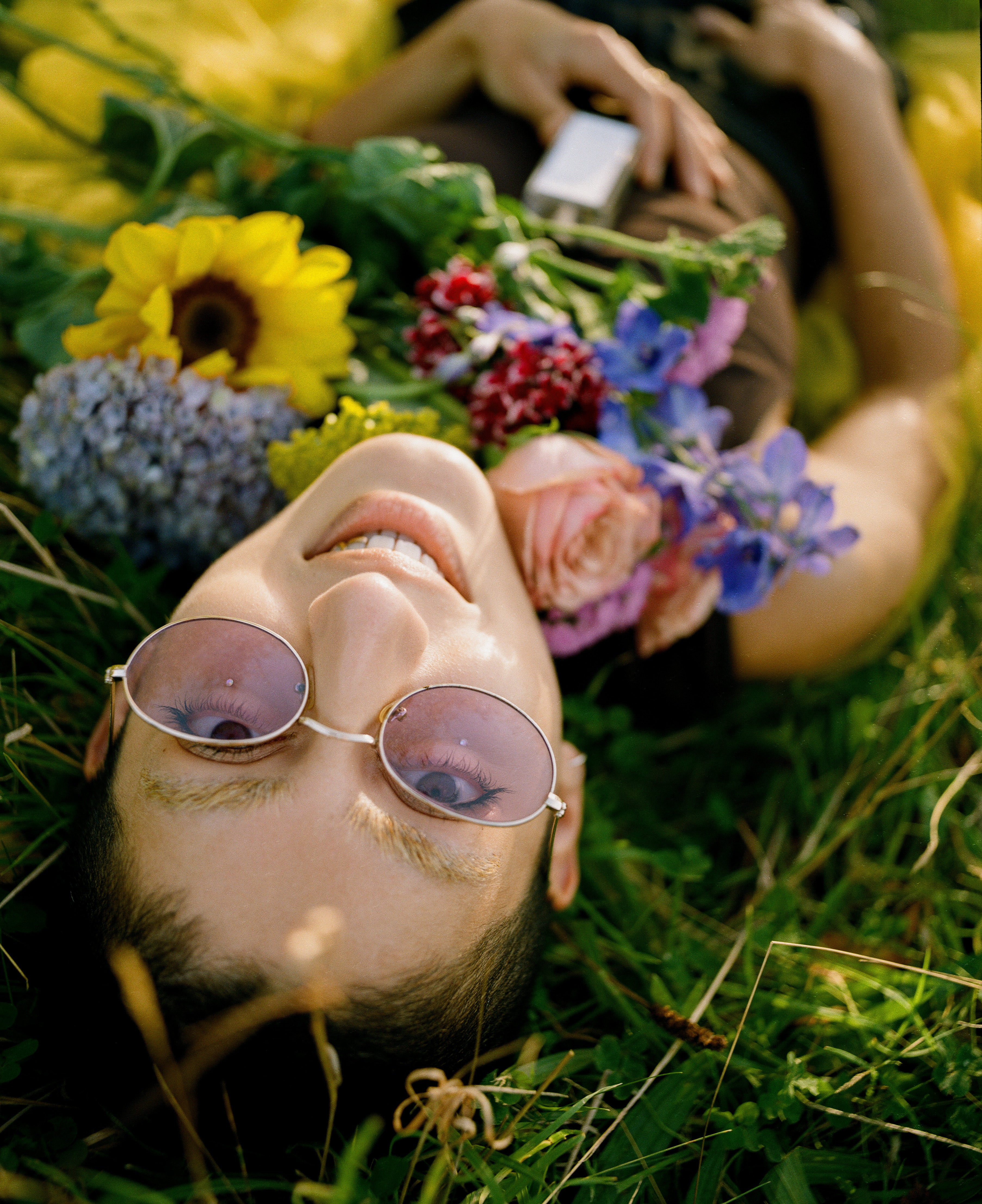Jorum Studio Winter Campaign model lies in grass with flowers