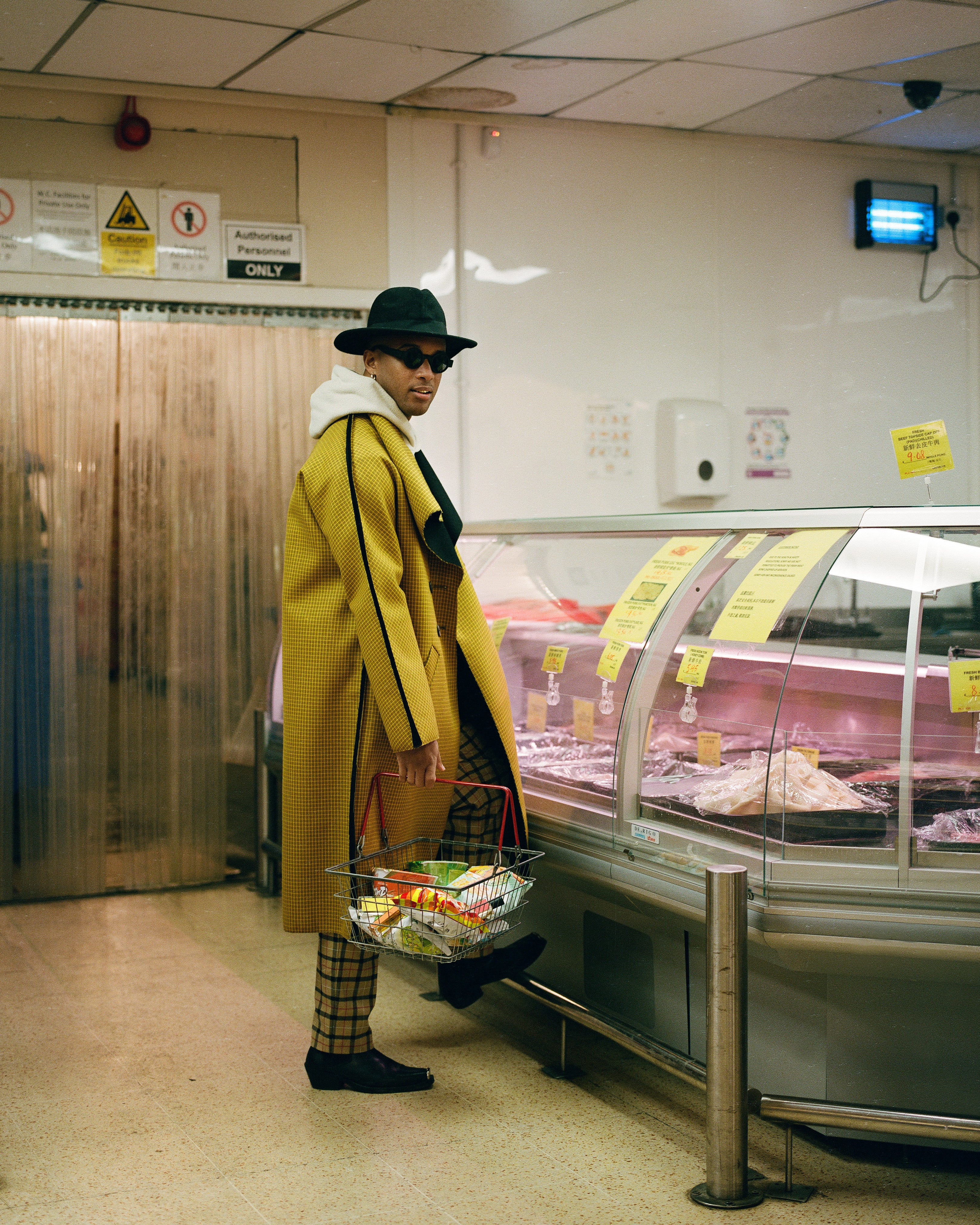 Jorum Studio Winter Campaign model standing in sunglasses and hat in Chinese supermarket