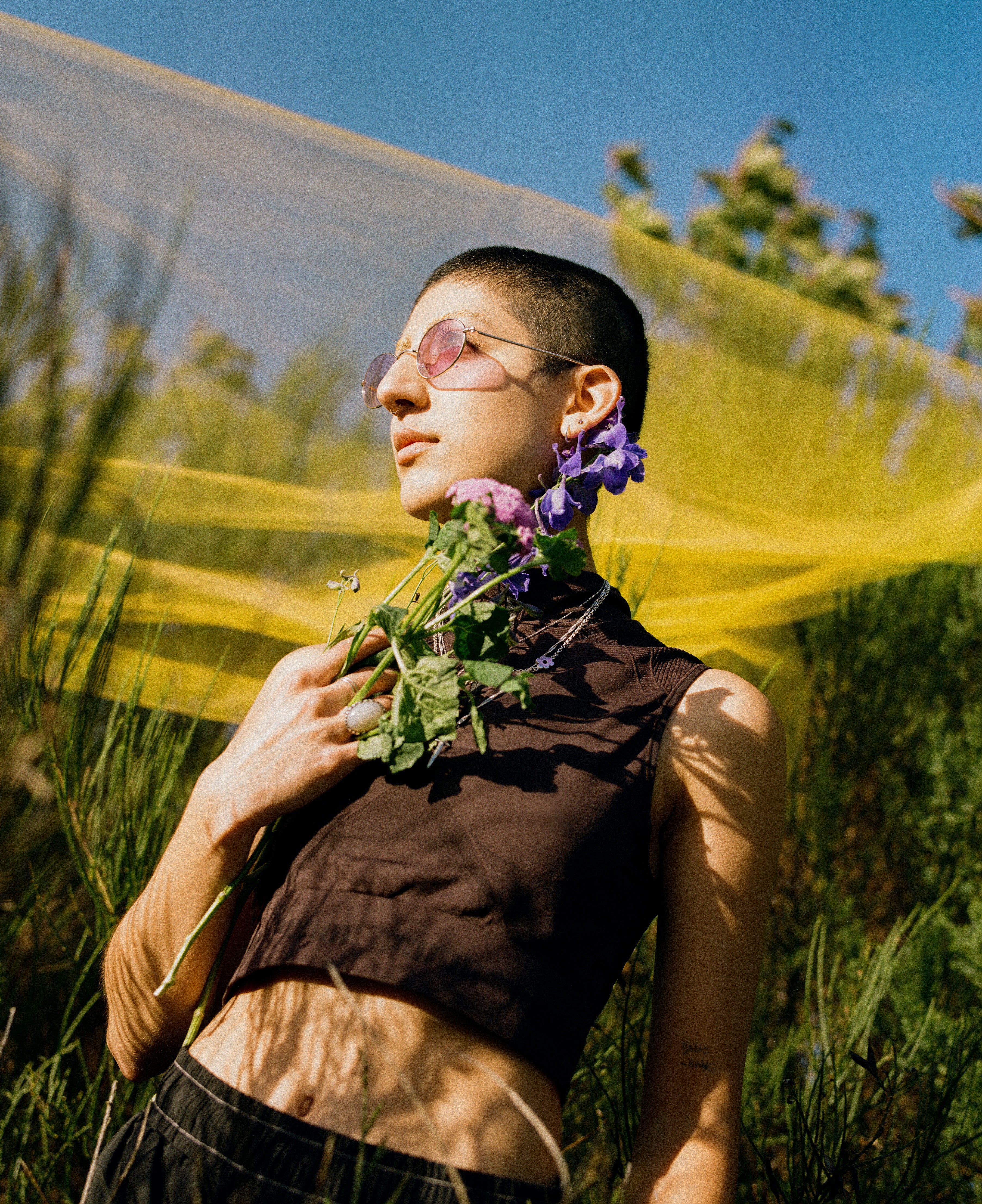 Jorum Studio Winter Campaign model poses with flowers in front of yellow gauze