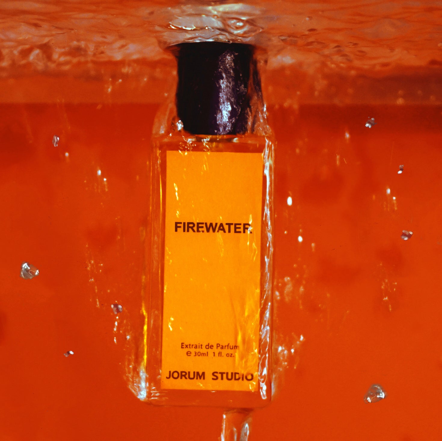 Bottle of Jorum Studio Firewater perfume with water pouring update down and orange background