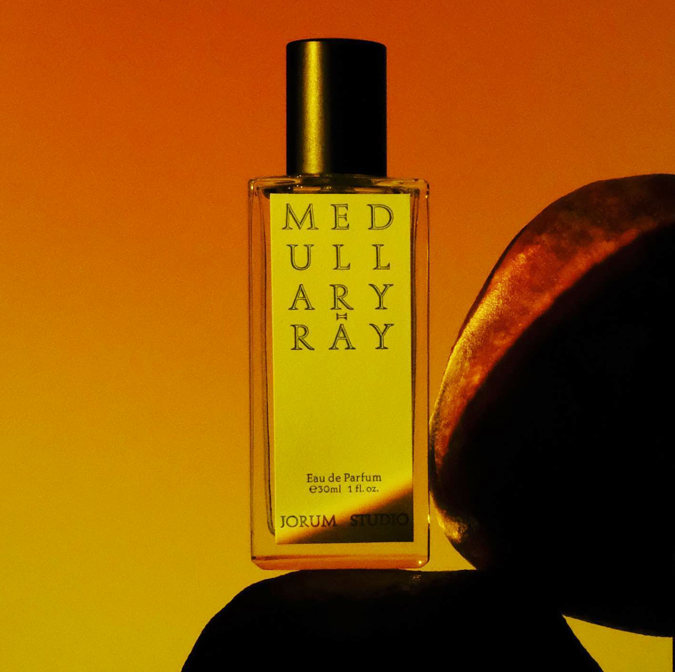 Sunlit bottle of Jorum Studio Medullary-Ray perfume with silhouettes of pomegranate