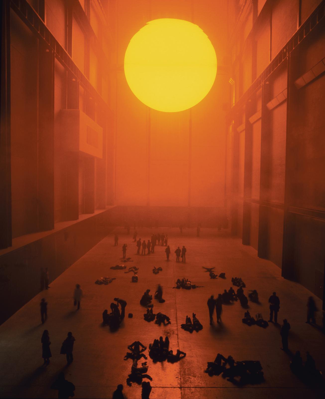 Atrium of the Tate Modern: a bright orange sphere casting light on onlookers