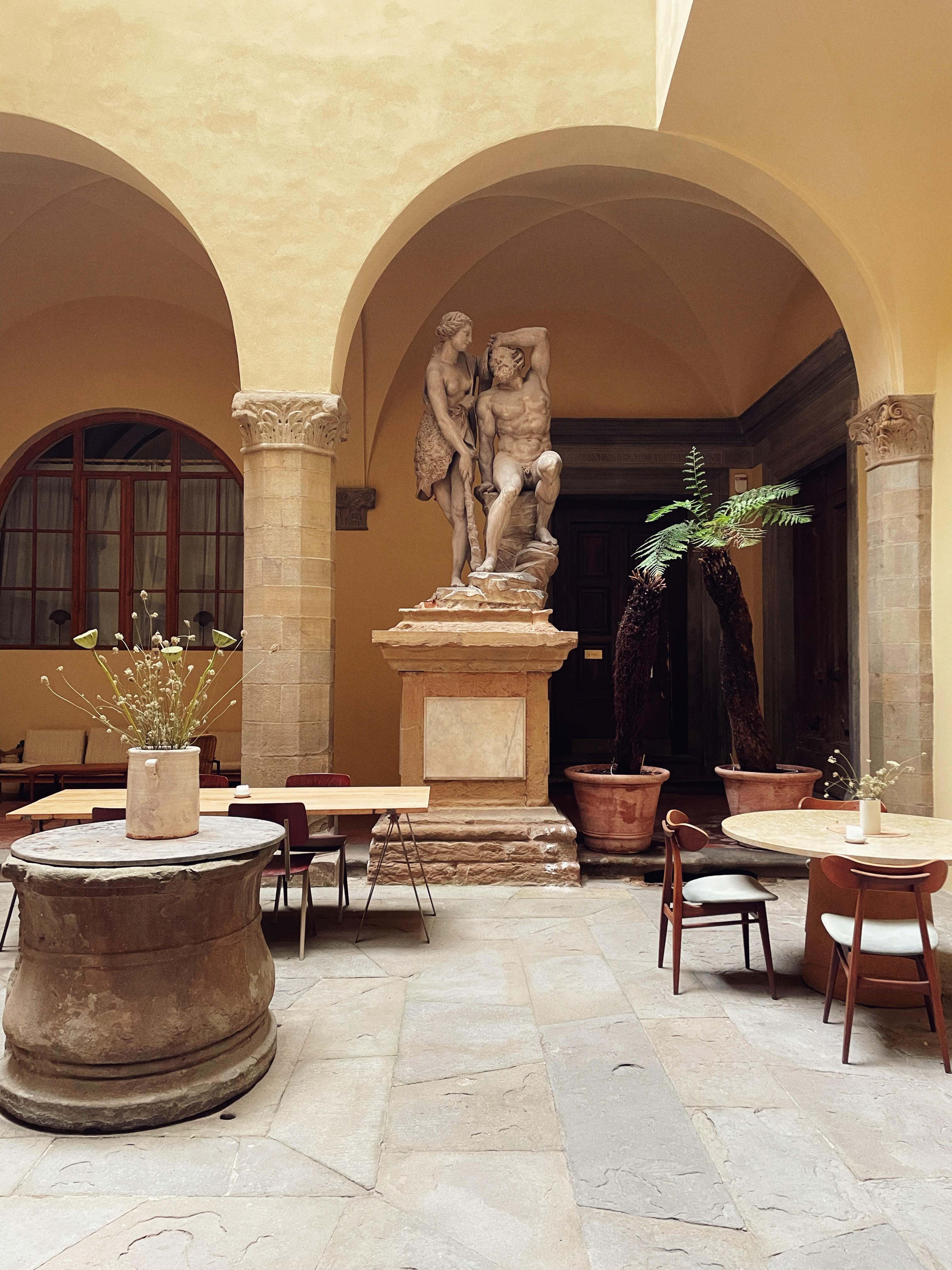 Internal Palazzo in Florence with columns and arches, Italian statues and palm trees