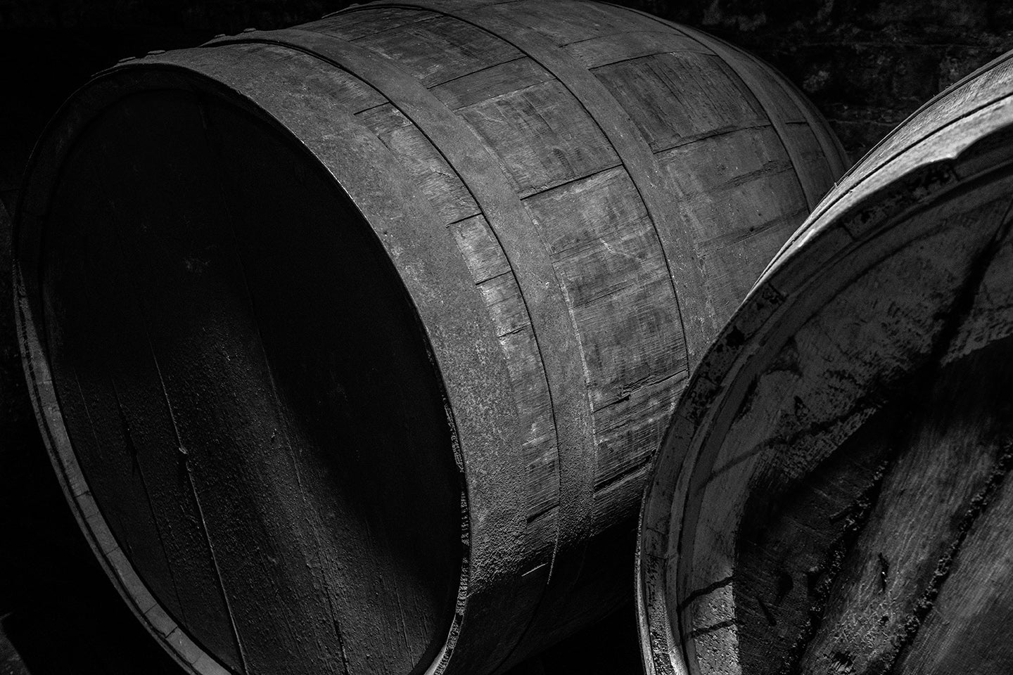 black and white photograph of stacked whisky casks by Craig McIntosh