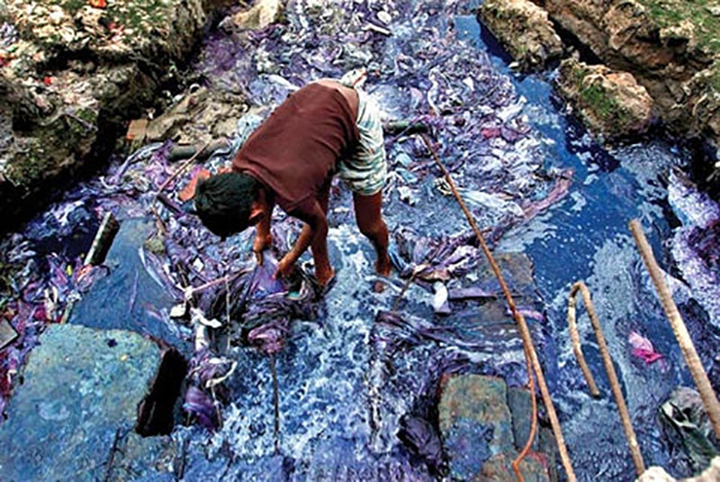 Boy working in dirty polluted water