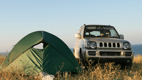 a ground tent next to a SUV