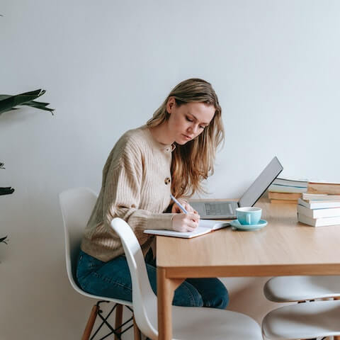 Creative entrepreneur writing in her planner