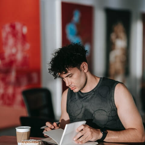 Fitness creative entrepreneur writing in his journal