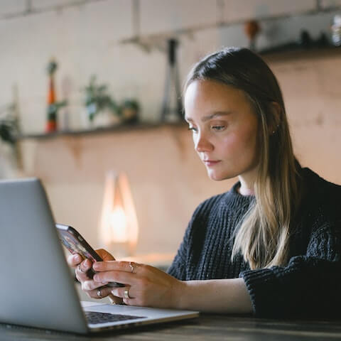 Innovative female, creative entrepreneur writing message on her phone