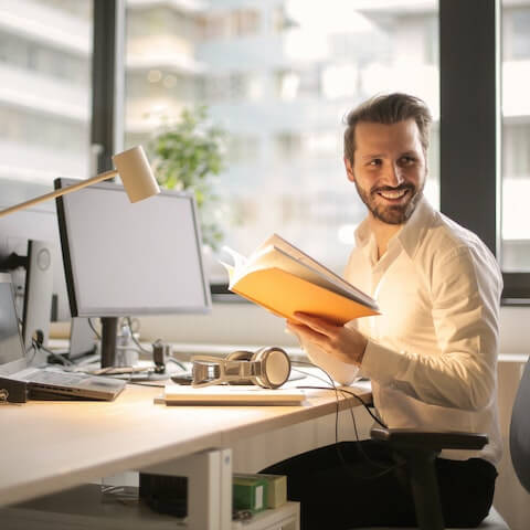 creative business owner happily reading book