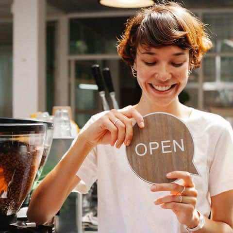 female entrepreneur holding open sign