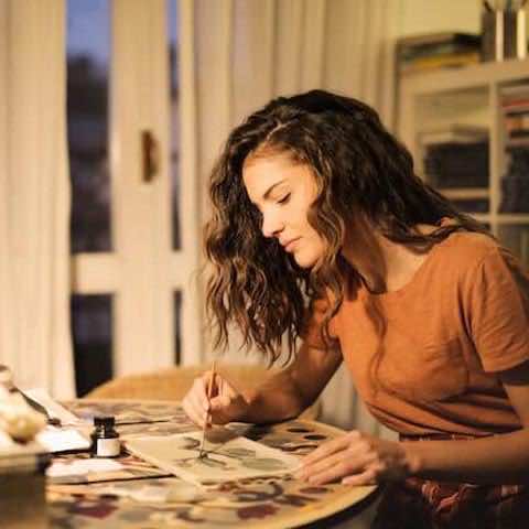 creative entrepreneur sat at her desk painting