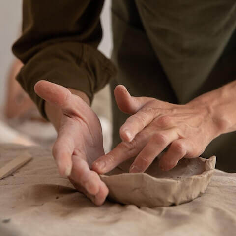 male artist making clay sculpture