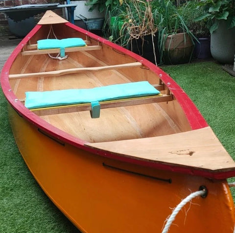 home made wool-stuffed cushions placed across canoe seats