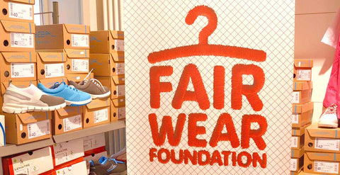 Arbeitsschuhe und ein Aufsteller mit der Aufschrift "Fair Wear Foundation"