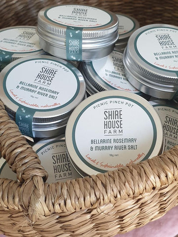 Basket full of round tins with a branded label on them