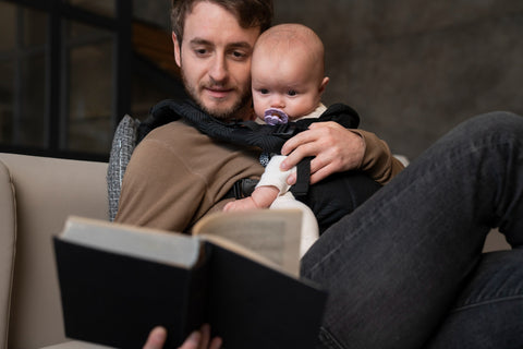 father holding baby and reading