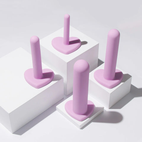 A purple dilator kit with heart shaped bases set out on white stands to show the size progression