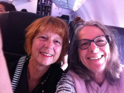 Two ladies in an airplane taking a selfie one with a short haircut with red hair and the other with shoulderlength hair and glasses Sarah Baker and Sue Duffy