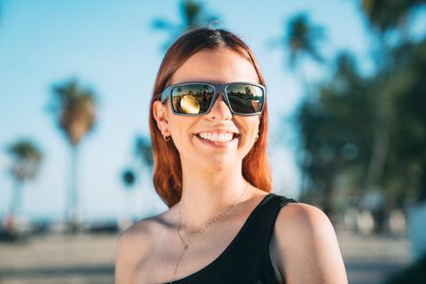 a woman wearing Torege UV-resistant sunglasses in sunny summer outdoor setting