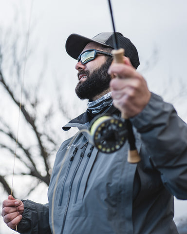 a man angler holding a fishing rod outdoors wearing Torege polarized fishing sunglasses