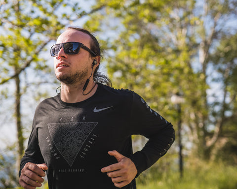 a man running outdoors wearing Torege sports sunglasses