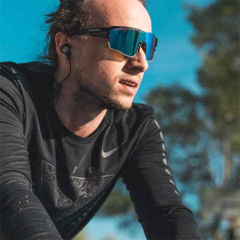 a man sitting on a bike outdoors wearing Torege sport sunglasses